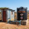 Borehole pump house next to a water storage tank at a Kenyan property